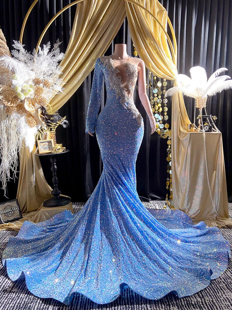 Light blue one-sleeve sequin ball gown with crystal embellishments, featuring a modern silhouette and shimmering details.
Light blue one-sleeve sequin ball gown with crystal embellishments, featuring a modern silhouette and shimmering