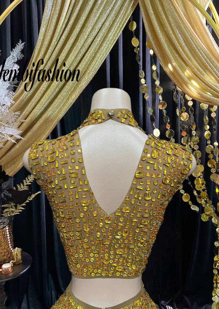 A luxurious gold diamante set dress with intricate diamante embellishments, featuring a figure-hugging silhouette, perfect for special occasions and formal events.