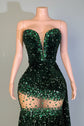 Green sequin dress on a mannequin with a visible brand tag, indoor setting.