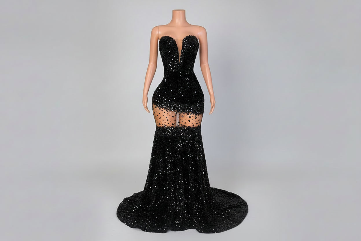 Black sequin evening gown on a mannequin against a decorative wall.