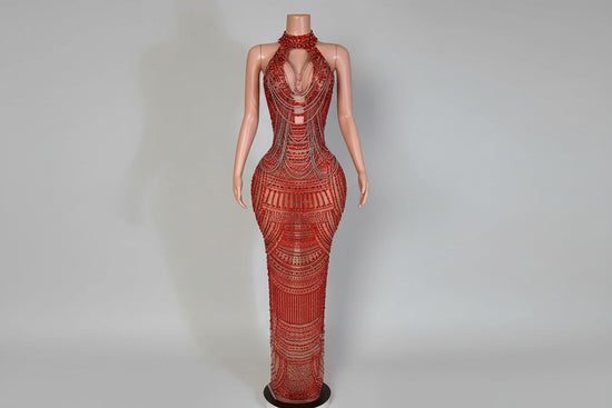 Mannequin wearing a red beaded evening gown in an elegant room setting.