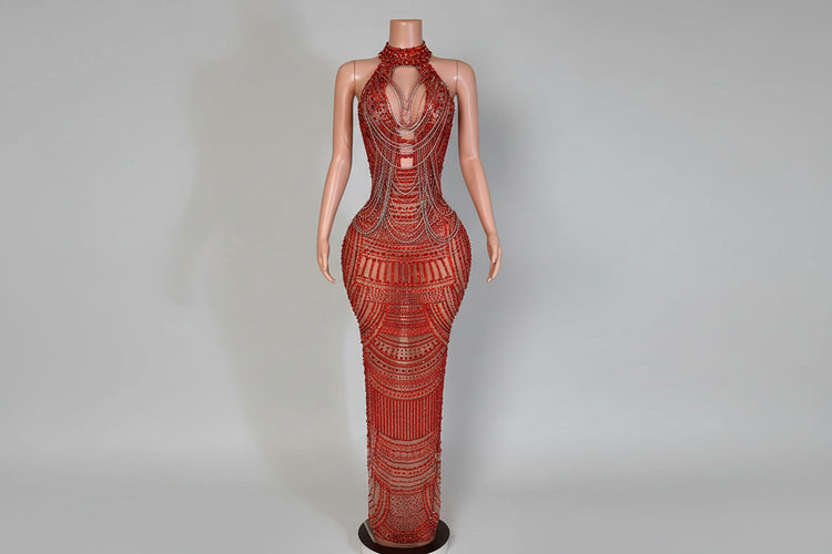 Mannequin wearing a red beaded evening gown in an elegant room setting.