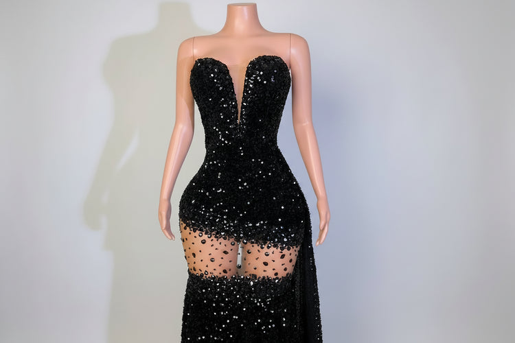 Black sequin dress on a mannequin with a blurred indoor background