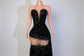 Black sequin dress on a mannequin with a blurred indoor background