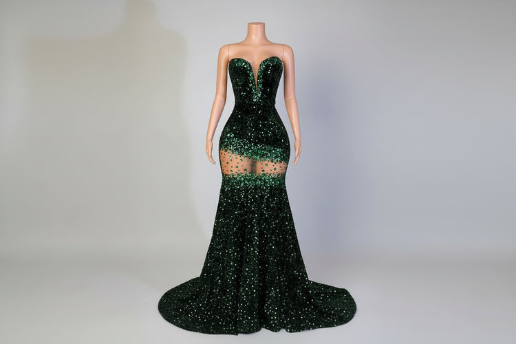 Mannequin wearing a green sequin dress in an elegant room with a plant and chair.
