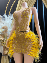 A vibrant yellow mini dress adorned with feathers and rhinestones, perfect for glamorous events and parties.
