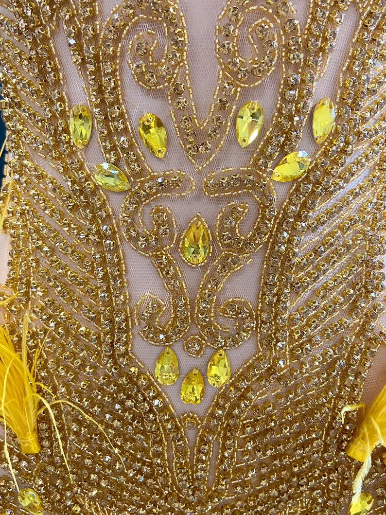 A vibrant yellow mini dress adorned with feathers and rhinestones, perfect for glamorous events and parties.