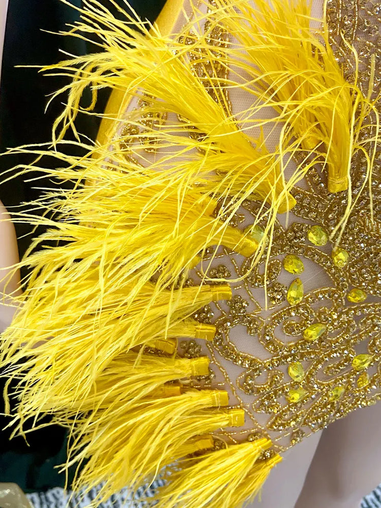 A vibrant yellow mini dress adorned with feathers and rhinestones, perfect for glamorous events and parties.