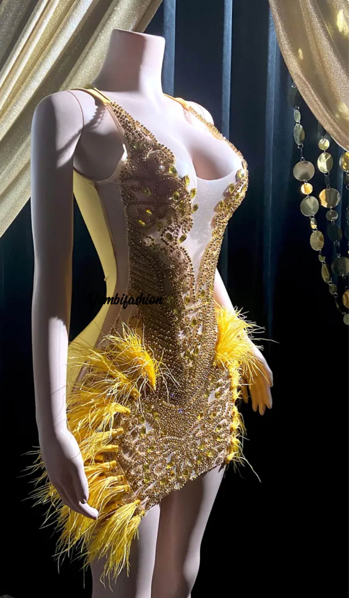 A vibrant yellow mini dress adorned with feathers and rhinestones, perfect for glamorous events and parties.