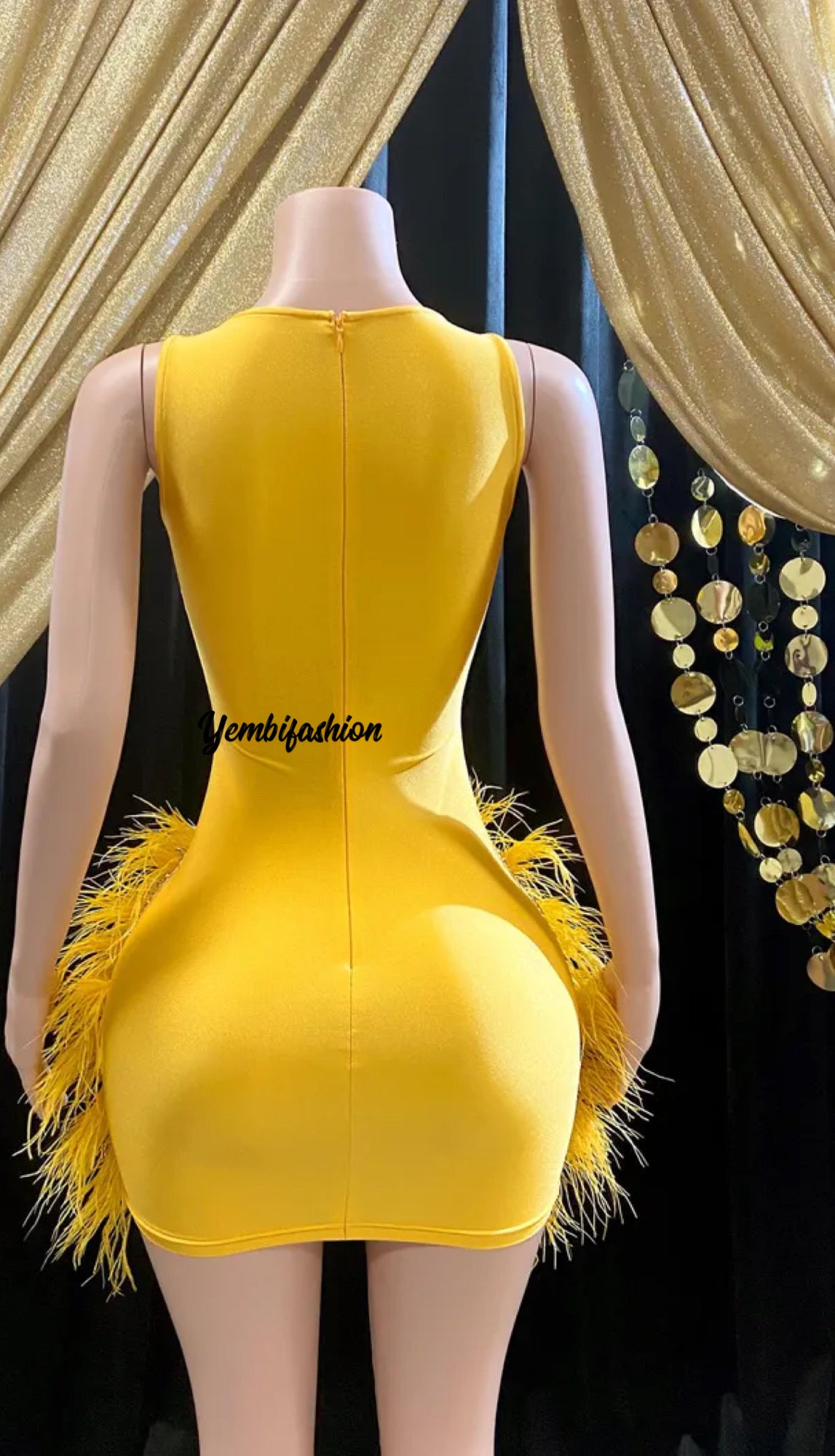 A vibrant yellow mini dress adorned with feathers and rhinestones, perfect for glamorous events and parties.