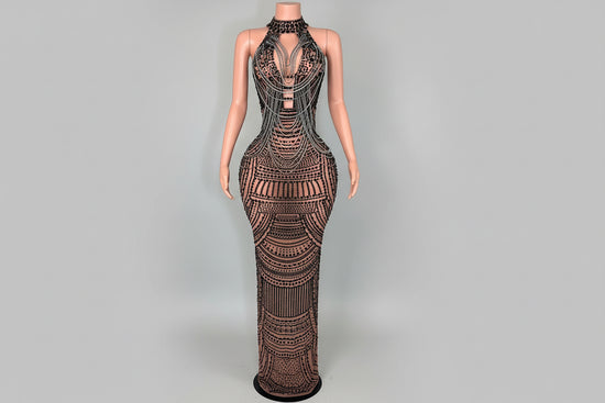 Mannequin wearing a detailed evening gown in a room with decorative elements.