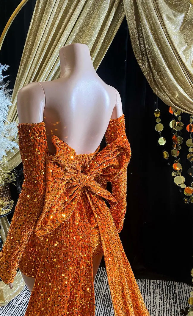 A vibrant orange Eve Sequin Evening Dress styled as a ball gown, with intricate crystal embellishments and shimmering sequins, perfect for formal occasions and elegant events.